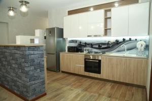 a kitchen with a stove and a refrigerator at Gio&Mai Appartment in Tbilisi City