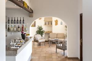 een proefruimte met een tafel en stoelen en wijnflessen bij Hotel Sole Mare in Baja Sardinia