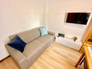 een woonkamer met een bank met twee blauwe kussens bij Duomo a 15 minuti - Lussuoso appartamento in Milaan