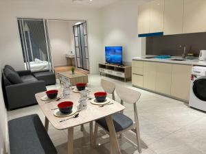 cocina y sala de estar con mesa y sillas en Quill Residence KL by Bamboo Hospitality, en Kuala Lumpur