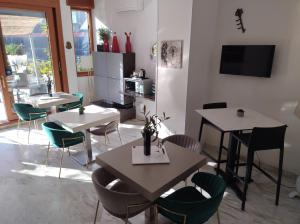 un soggiorno con tavoli e sedie e una cucina di B&B Mini Hotel Incity-close train station and port- a Salerno