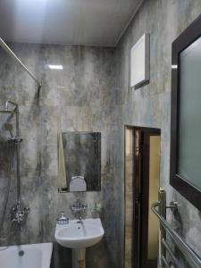 La salle de bains est pourvue d'un lavabo et d'un miroir. dans l'établissement SAFAR hotel, à Tachkent