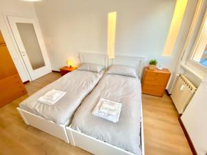 een slaapkamer met een wit bed met 2 kussens bij Duomo a 15 minuti - Lussuoso appartamento in Milaan
