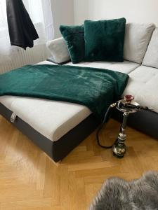 um cobertor verde numa cama ao lado de um sofá em MM Luxury Apartments em Viena