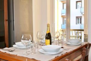 een tafel met glazen en een fles wijn bij Duomo a 15 minuti - Lussuoso appartamento in Milaan