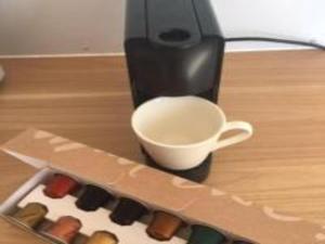 una cafetera con una taza sobre una mesa en White Jacaranda Tiny House en Maleny