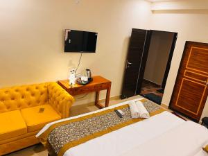 Pokój hotelowy z kanapą i telewizorem w obiekcie House Of Ubuntu w mieście Rāmtek