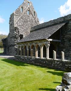 une ancienne église en pierre avec une tour et de l'herbe verte dans l'établissement Craigielea Cottage, à Newton Stewart