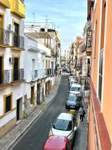 een straat met auto's aan de kant van de weg bij Hispalis Columnas de la Alameda in Sevilla