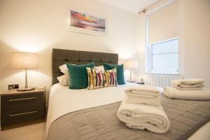 a bedroom with a bed with towels on it at Urban Living's - King Edward Luxury Suites in Windsor