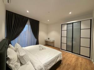 Quill Residence KL by Bamboo Hospitality في كوالالمبور: غرفة نوم بسرير ابيض ونافذة