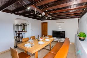 Un comedor con mesa y sillas y un televisor. en Villa Sara, en Playa Blanca