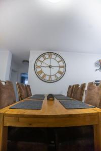 a wooden table with chairs and a clock on the wall at High-quality renovated apt (TLA/Tlf/TDY-RAB) in Ramstein-Miesenbach