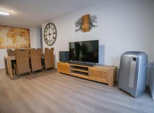 a living room with a flat screen tv and a table at High-quality renovated apt (TLA/Tlf/TDY-RAB) in Ramstein-Miesenbach