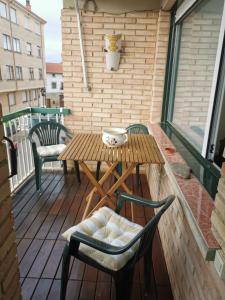 een houten tafel en stoelen op een balkon bij RIOJADOMUS in Anguciana