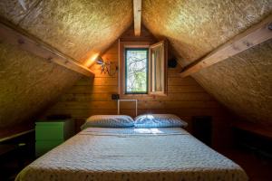 1 dormitorio con 1 cama en una habitación con ventana en Casetta Pizziddu, en San Giovanni Gemini