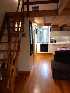 ein Wohnzimmer mit einer Treppe und eine Küche in der Unterkunft Charmant gîte avec parking gratuit sur place. in Davézieux