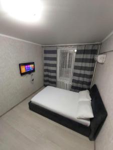 a small bedroom with a bed and a television at Отличная квартира со всеми удобствами. in Almaty