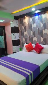 ein Schlafzimmer mit einem großen Bett mit zwei roten Kissen in der Unterkunft Hotel sweta villa & banquet hall in Bankipur