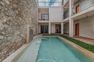 a swimming pool in front of a building at Hotel Casa 57 in Mérida