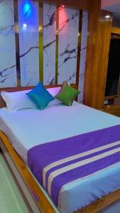 ein großes Bett mit zwei Kissen darüber in der Unterkunft Hotel sweta villa & banquet hall in Bankipur