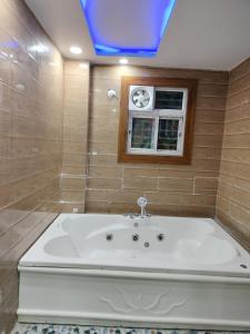 eine große weiße Badewanne im Bad mit Fenster in der Unterkunft Hotel sweta villa & banquet hall in Bankipur
