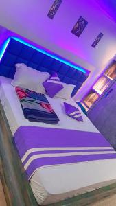 Cama en habitación con iluminación púrpura en Hotel sweta villa & banquet hall, en Bankipur