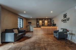 una sala de estar con 2 sofás y un bar en Hotel Casa 57 en Mérida