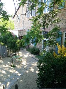 un jardín frente a un edificio de ladrillo en Charmant gîte avec parking gratuit sur place. en Davézieux