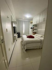 a white bedroom with a bed and a mirror at APARTAMENTO IMPERIAL IV (COMPLETO) in Castanhal