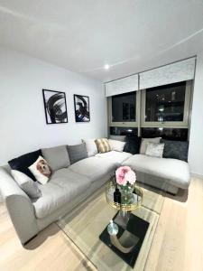 a living room with a couch and a glass table at Stylish Apartment Docklands in London
