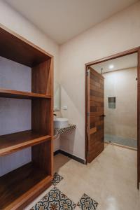 baño con ducha, aseo y puerta en Hotel Casa 57 en Mérida