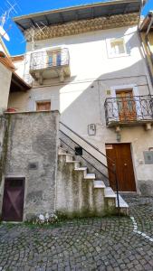 ein Gebäude mit einer Treppe, einer Tür und einem Balkon in der Unterkunft Casa Lu' in Rocca Pia