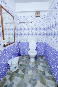 Habitación púrpura con baño y aseo. en EL LORA RESlDENCY, en Munnar