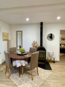 a dining room with a table and a wood stove at Maison au coeur de la Dombes in Le Plantay +3 photos