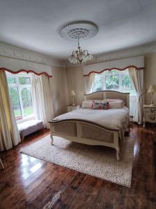 a bedroom with a large bed and two windows at Entire home at Ballysax House in Newpark