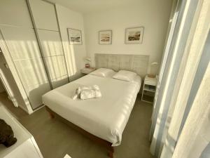 een slaapkamer met een groot wit bed met twee kussens bij PGH N25 - Vue Mer, Première Ligne & Parking Privé in La Grande-Motte