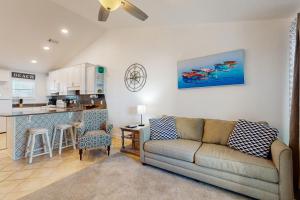 a living room with a couch and a kitchen at Baywatch F9 in Pensacola Beach