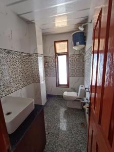 a bathroom with a sink and a toilet and a window at Snowline Homestay in Kīar
