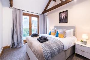 Un dormitorio con una cama grande y una ventana en Stunning Old Forge with Huge Balcony, en Leamington Spa