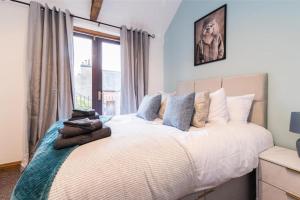 a bedroom with a large bed with pillows on it at Stunning Old Forge with Huge Balcony in Leamington Spa