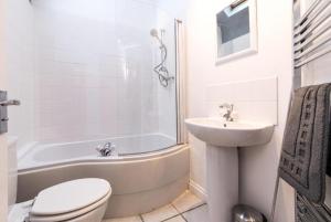 a white bathroom with a toilet and a sink at Stunning Old Forge with Huge Balcony in Leamington Spa