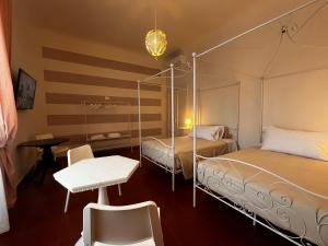 フィレンツェにあるB&B Dante Alighieriのベッドルーム1室(ベッド2台、テーブル、椅子付)
