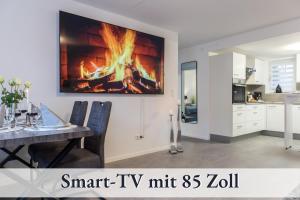 uma cozinha e sala de jantar com lareira na parede em RelaxApartment 15 Massagesessel SmartTV Küche em Biberach an der Riss