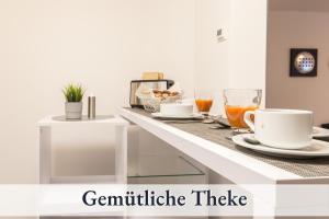 a white counter with two cups and drinks on it at RelaxApartment 15 Massagesessel SmartTV Küche in Biberach an der Riß