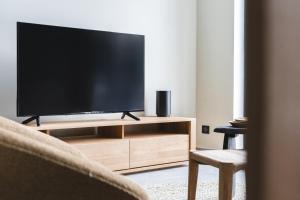 a flat screen tv sitting on a wooden entertainment center at Les Chalets du Grand Hôtel in Saint-Chaffrey