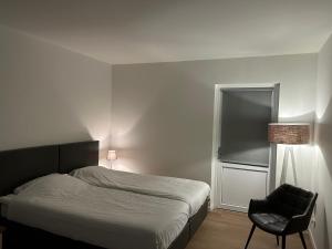ein Schlafzimmer mit einem Bett, einem Stuhl und einem Fenster in der Unterkunft Hotel Nijeveen in Nijeveen
