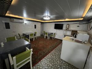 una sala con tavoli e sedie e una cucina di TINY ART HOUSE HOTEL near Airport of Samarkand a Samarkand