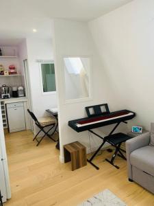 a living room with a piano in the corner of a room at Studio cosy au cœur de Paris in Paris