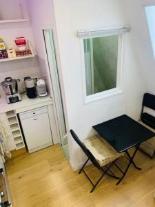 a table and a chair in a small room at Studio cosy au cœur de Paris in Paris